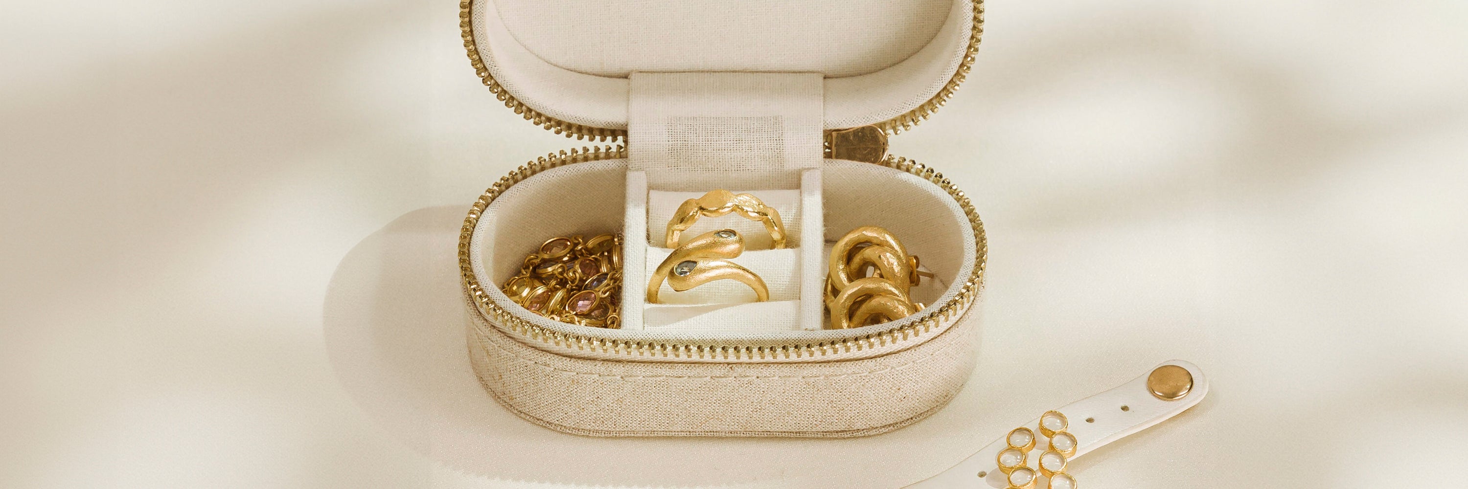 Spiegel auf dem ein Glas und ein Marmorstein mit einer Halskette liegt